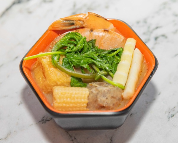 Tom yum broth delivery bowl with shrimp, fish cake, baby corn and watercress
