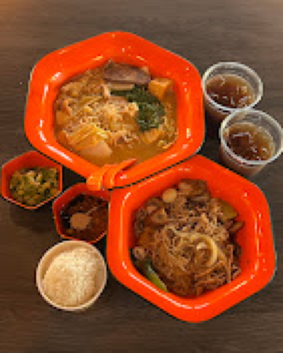 Fire Wok Hot Pot takeout bowls β two hexagonal containers with malatang, a side of rice, and dipping sauce cups